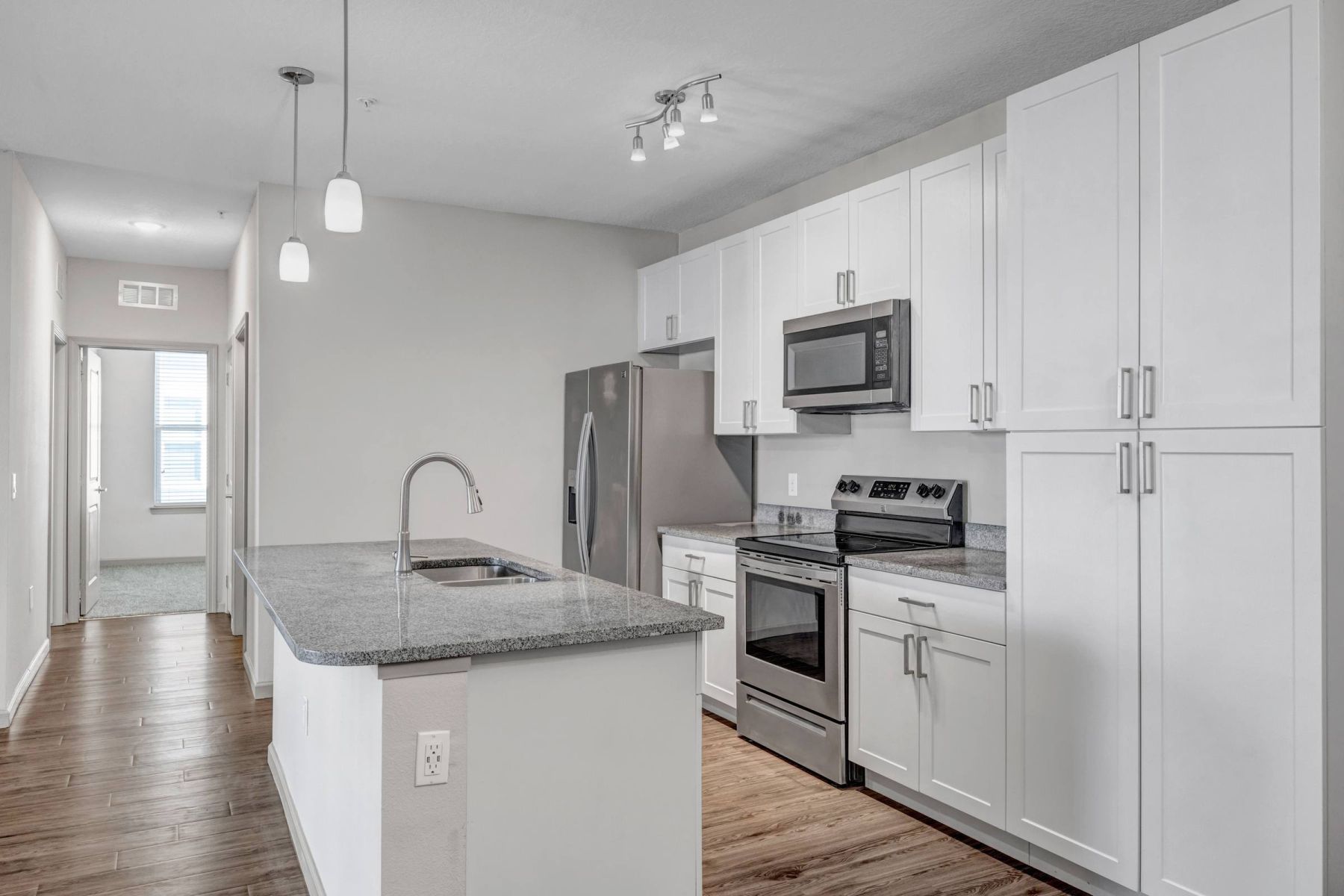 Luxury apartment kitchen with stainless steel appliances, granite countertops, and lots of storage space